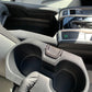 Close-up shot of a detailer holding a clean cup holder area, highlighting attention to detail in the cleaning process.