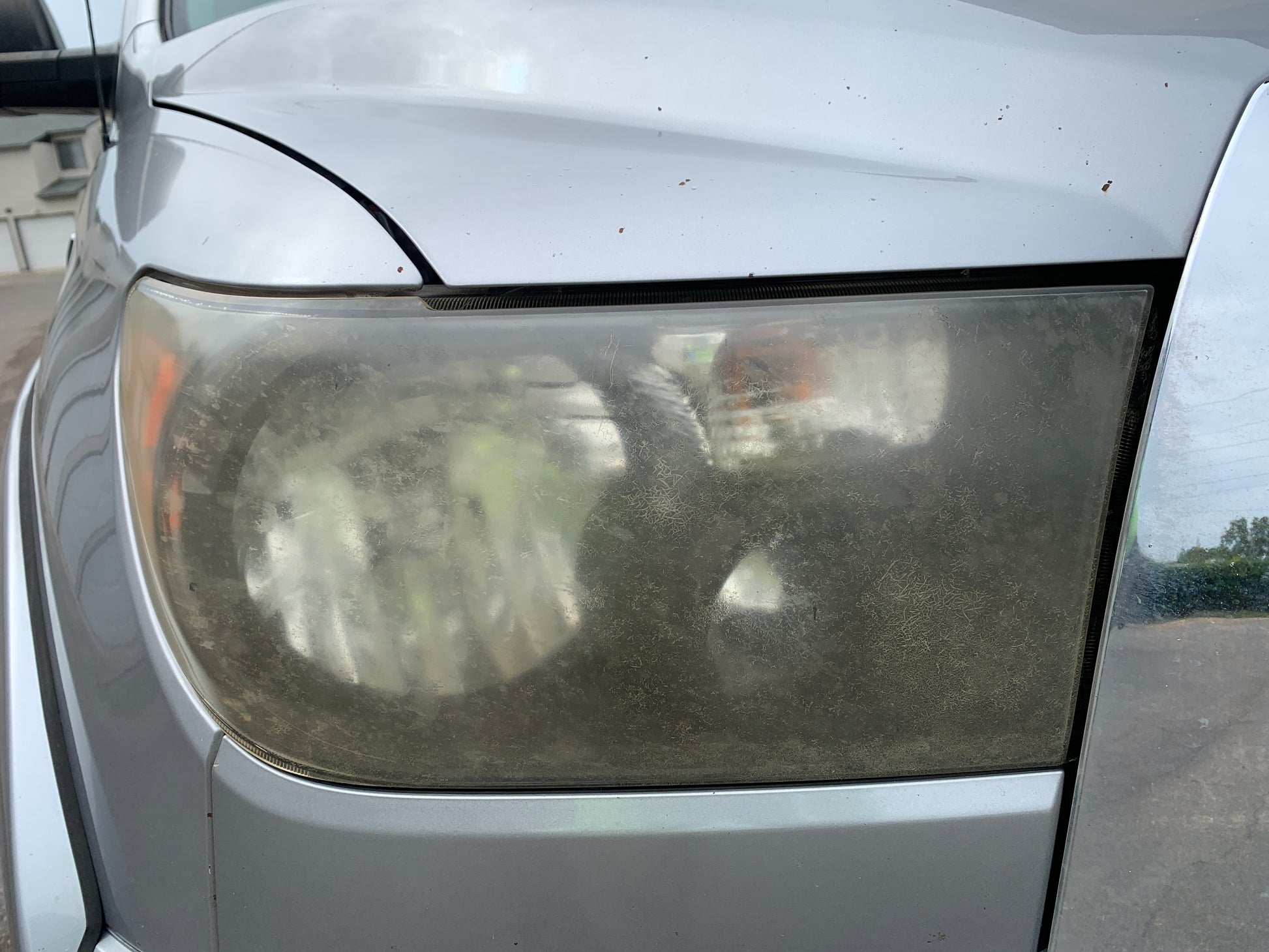 Headlights before being restored to clarity through professional detailing