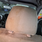 Headrest of a vehicle undergoing our Interior Revival Package. A striking half-and-half view shows dirty staining on one side and clean, refreshed fabric on the other.