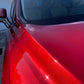 Close-up shot of red paint, highlighting the intricate speckles and texture of the freshly corrected and coated finish