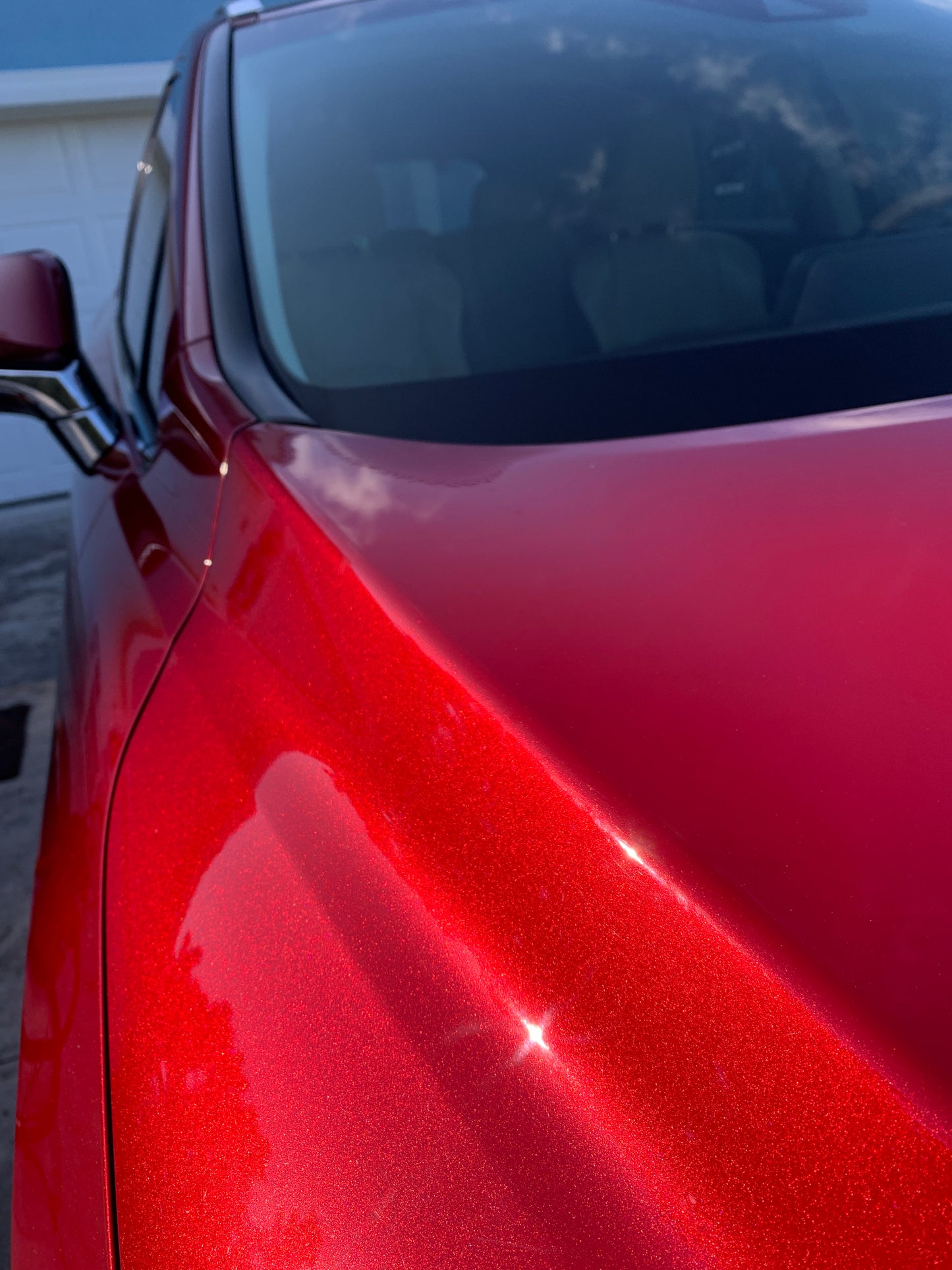Close-up shot of red paint, highlighting the intricate speckles and texture of the freshly corrected and coated finish