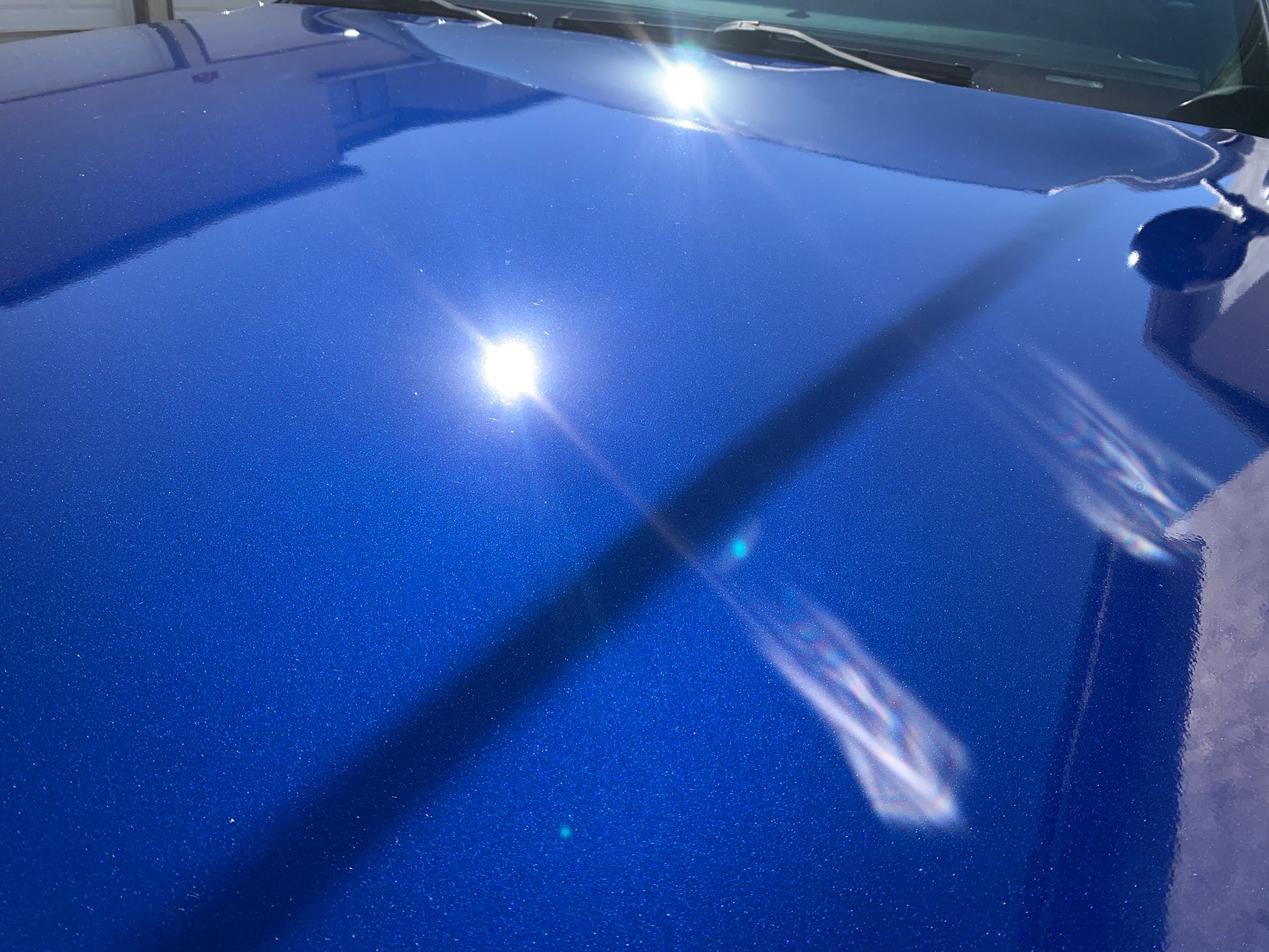 Close-up macro shot showcasing the paint speckling on the blue Ford Interceptor, revealing the smooth, textured finish after our correction and coating process