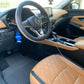 A close-up of a vehicle's interior after deep cleaning, highlighting the rejuvenated leather seats and spotless surfaces