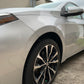 Low-angle shot from the front wheel, showcasing the entire side of a gleaming vehicle after professional detailing