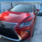 Wide-angle shot of a red car, showcasing the vibrant color and smooth, reflective finish after paint correction and ceramic coating