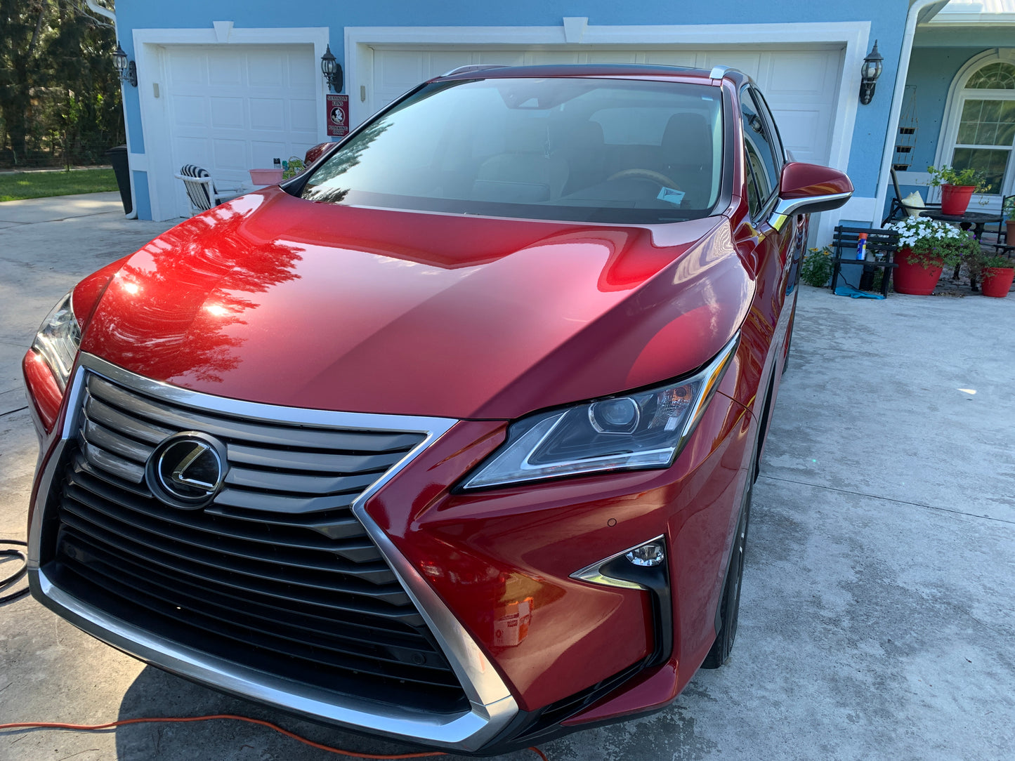 Wide-angle shot of a red car, showcasing the vibrant color and smooth, reflective finish after paint correction and ceramic coating